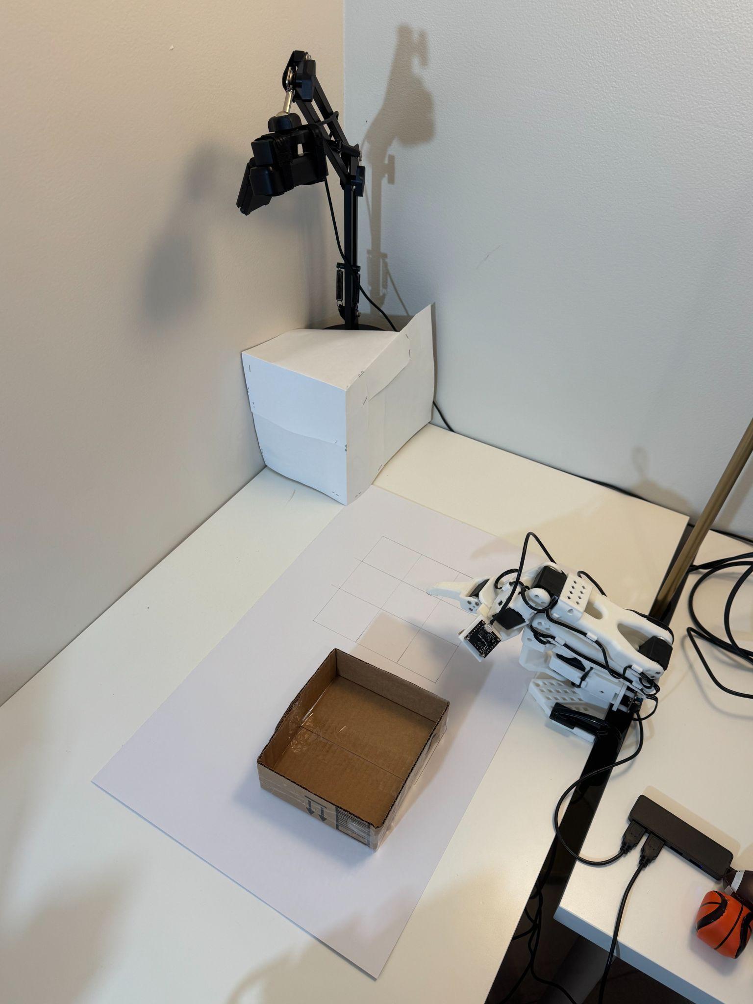 SO-101 robotic arm beside the target box, 3 by 3 grid, and fixed overhead camera